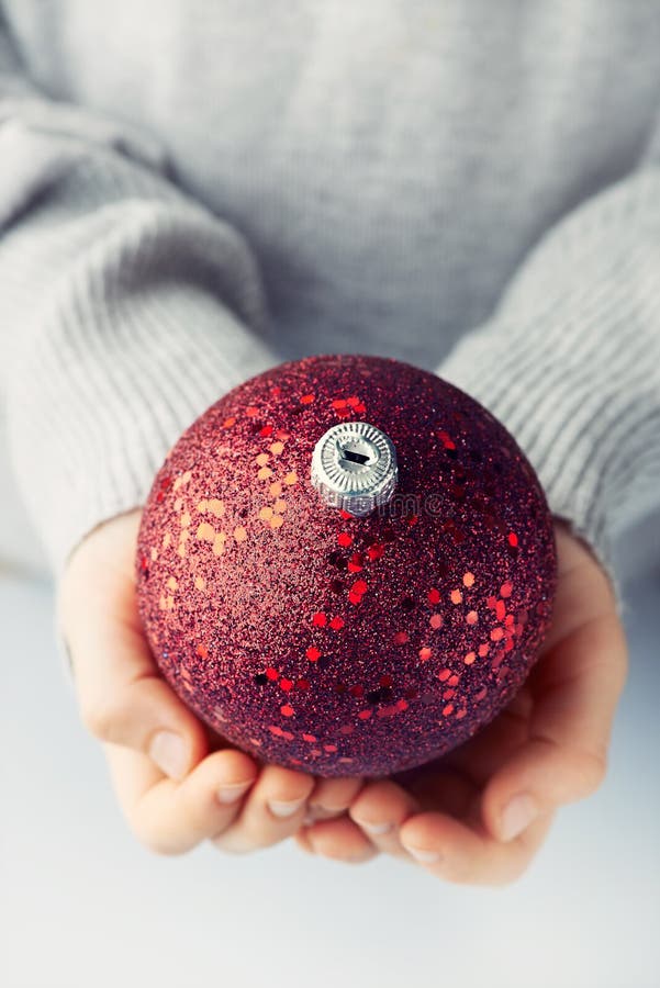 A child holding red christmas ball