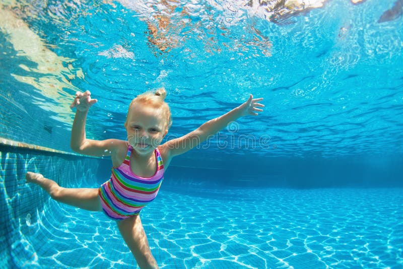 Child jump underwater into swimming pool