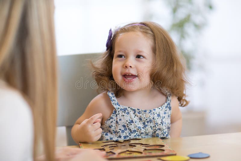 Child kid playing with puzzle shapes on table in children room in nursery or preschool. stock images Child kid playing with puzzle shapes on table in children room in nursery or preschool. stock images