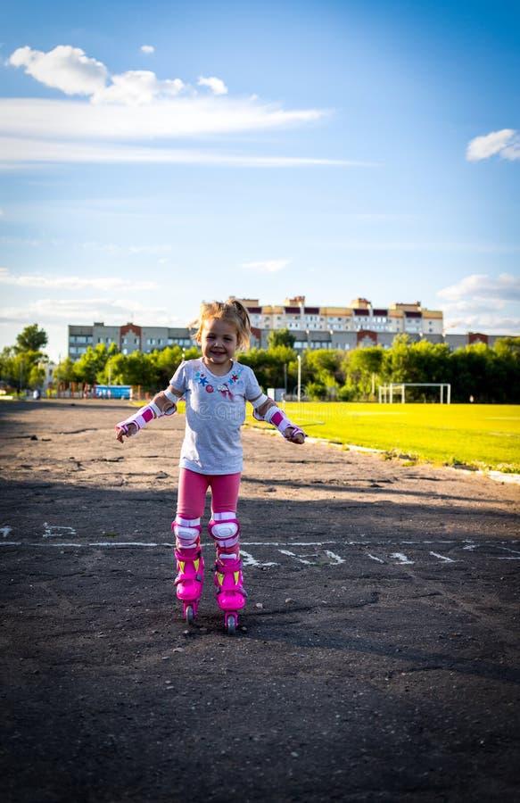 Child Learns To Roller Skate. Roller Skating Stock Photo Image of
