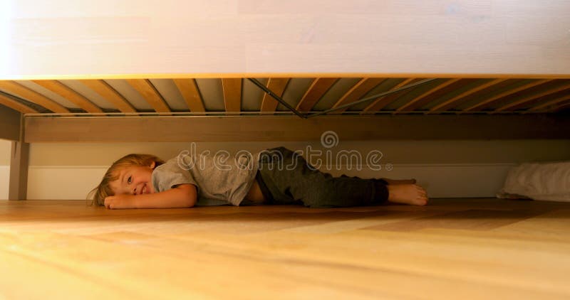 Child looking for something under the bed