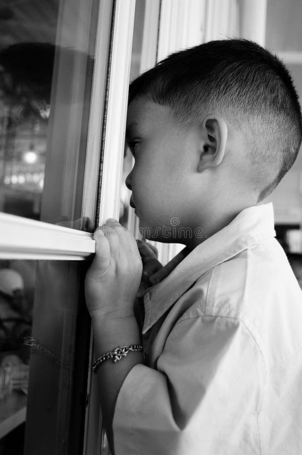 Child looking through a window, child longing