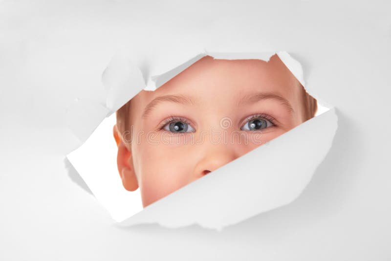 Child looks in hole in sheet of paper
