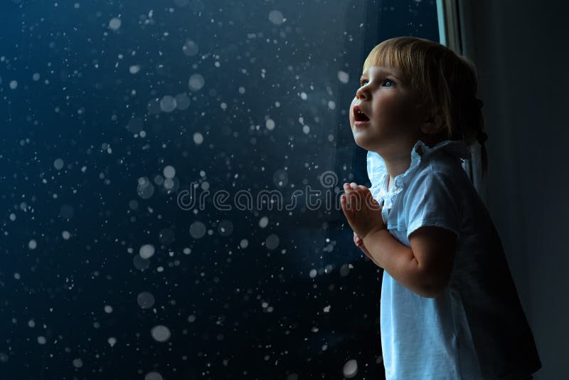 Child looks out the window on Christmas day