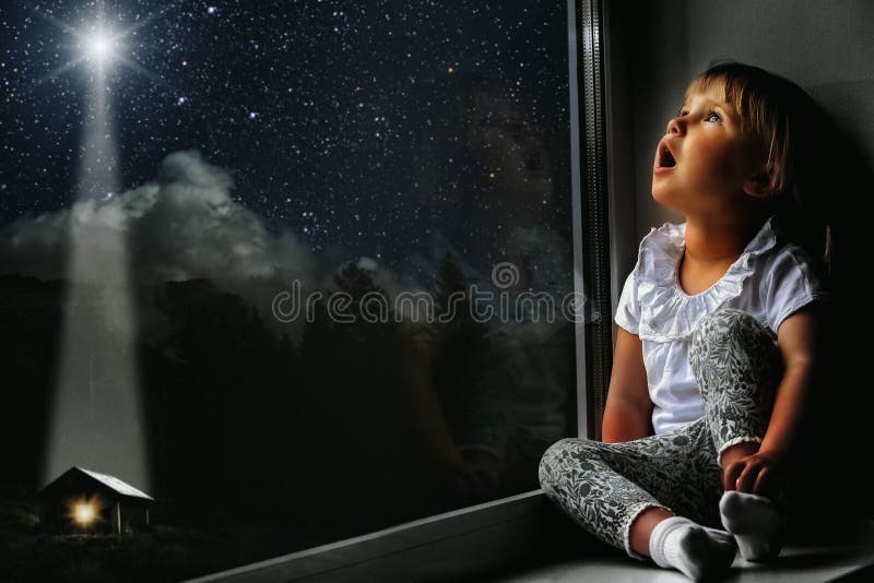 child looks out the window into the night sky