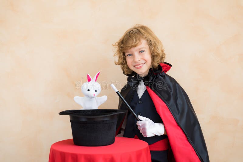 Child magician holding a top hat with toy rabbit stock photo Child magician holding a top hat with toy rabbit stock photo