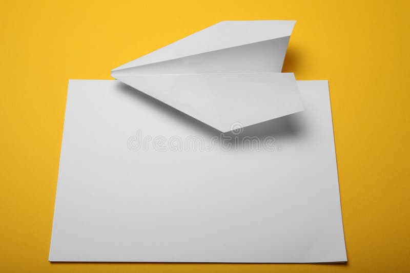 Child make paper airplane. Yellow background royalty free stock images