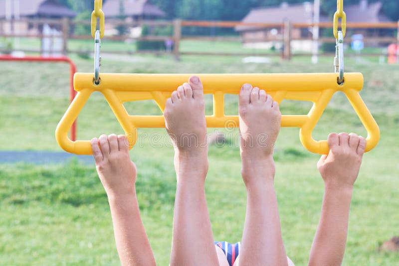 Child on monkey bars. Kid at beach playground. Little boy hanging on gym activity center of preschool play ground