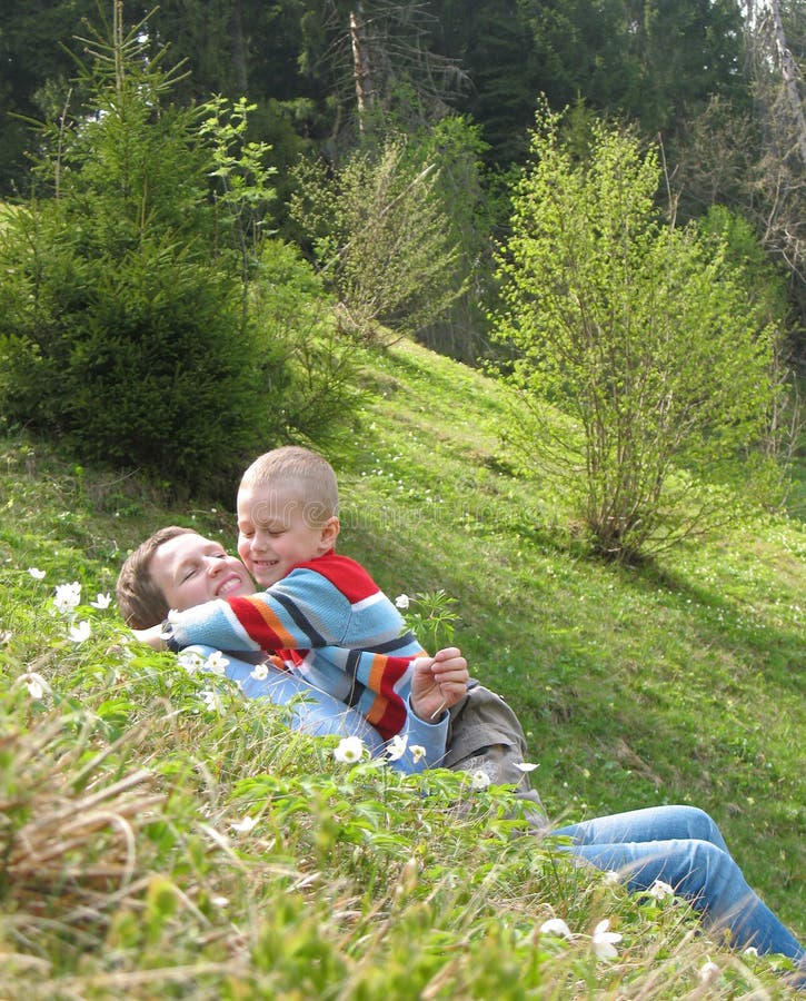 Child and mother play on grass