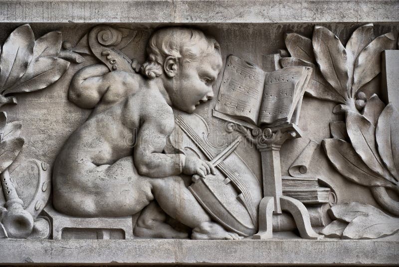 Child musician on a frieze. Detail on a sculpted fa�ade in the Grand Palais showing a child playing the violin royalty free stock image Child musician on a frieze. Detail on a sculpted fa�ade in the Grand Palais showing a child playing the violin royalty free stock image
