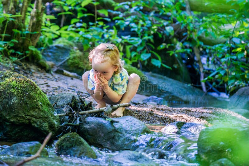 Child in nature water stream in forest