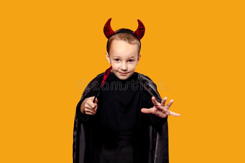 A Child on a Orange Background in a Fancy Dress Looks into the Camera and  Raises His Hands. the Concept of the Holiday - Halloween Stock Photo -  Image of little, beautiful: 199858956