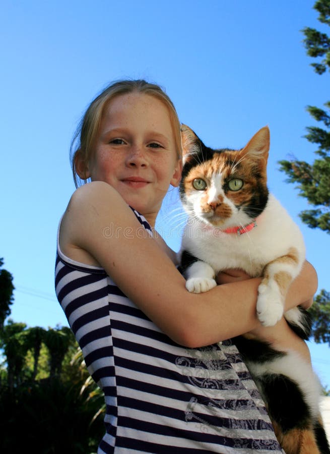 A white caucasian girl child holding her cat pet. A white caucasian girl child holding her cat pet