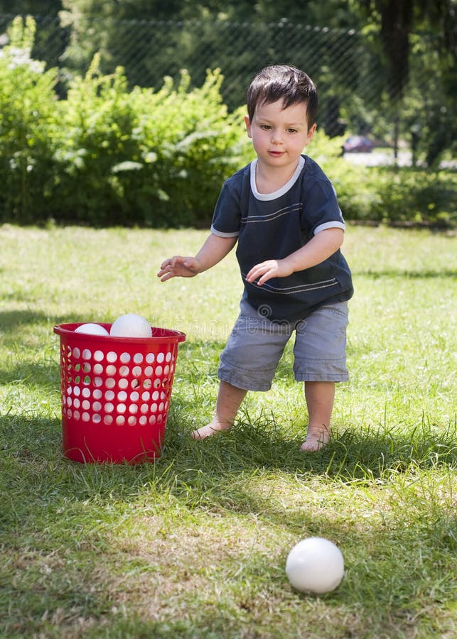 Child playing with balls in garden