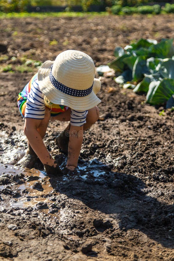 Child playing in mud. Selective focus. stock photos