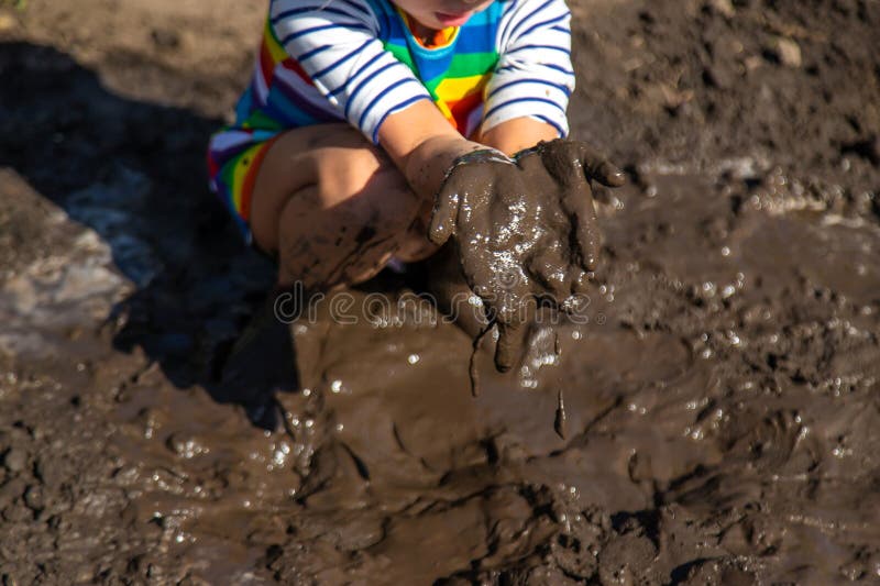 Child playing in mud. Selective focus. royalty free stock image