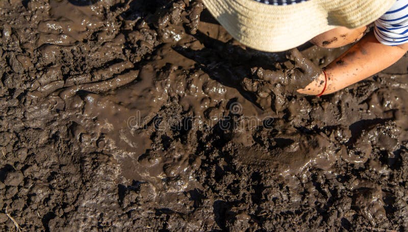 Child playing in mud. Selective focus. stock photography
