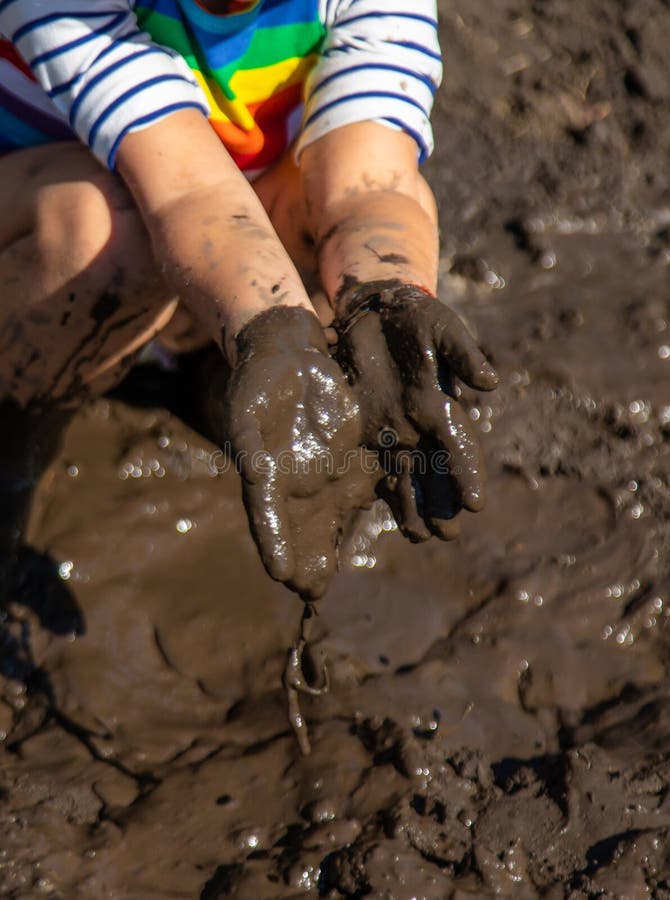 Child playing in mud. Selective focus. stock image