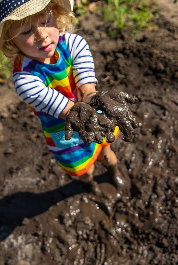Child playing in mud. Selective focus. stock photos