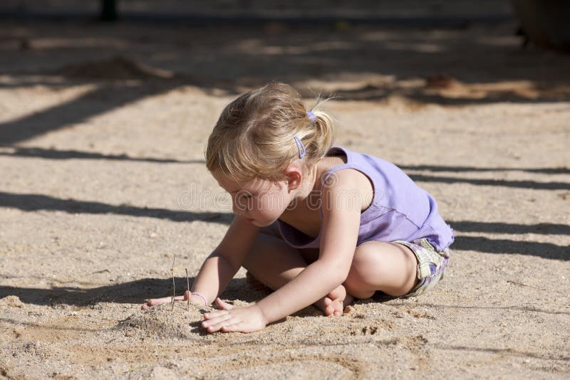 Child playing with sand on the playground