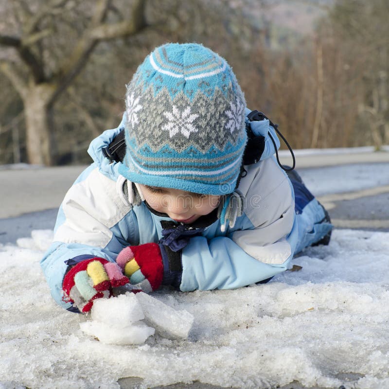 Child playing with snow and ice