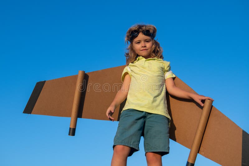 Child playing with toy jetpack on sky. Child pilot astronaut or spaceman dreams of flight. Aviator boy flying with a royalty free stock photo