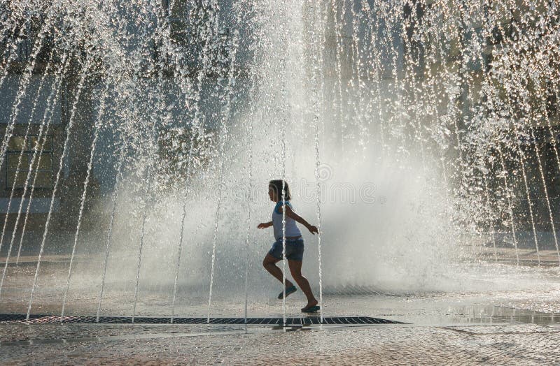 Child Playing in Water Fountain