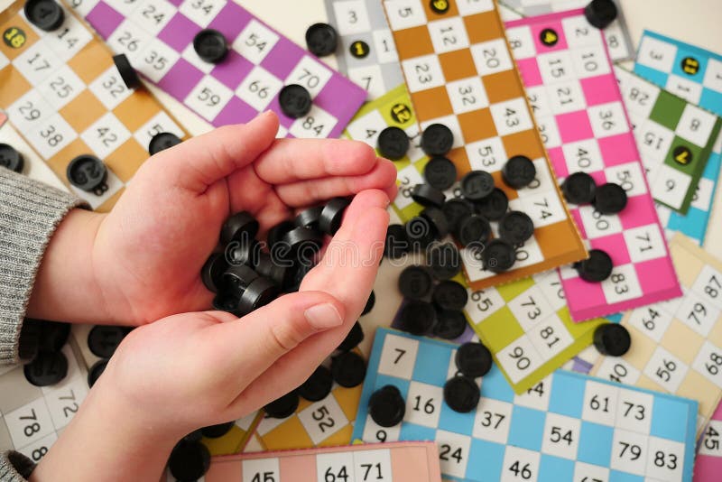 A Child Plays with Bingo Pieces,closeup a Hand Holds Bingo Pieces