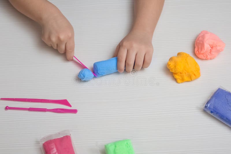 A child plays with colored plasticine.
