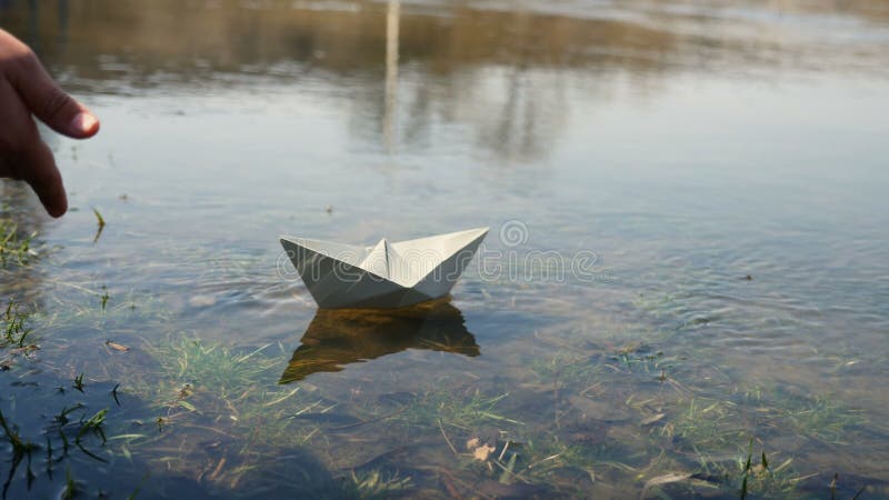 Child at the pond with a paper boat stock video