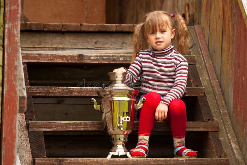 Child posing sitting near the Russian Samovar