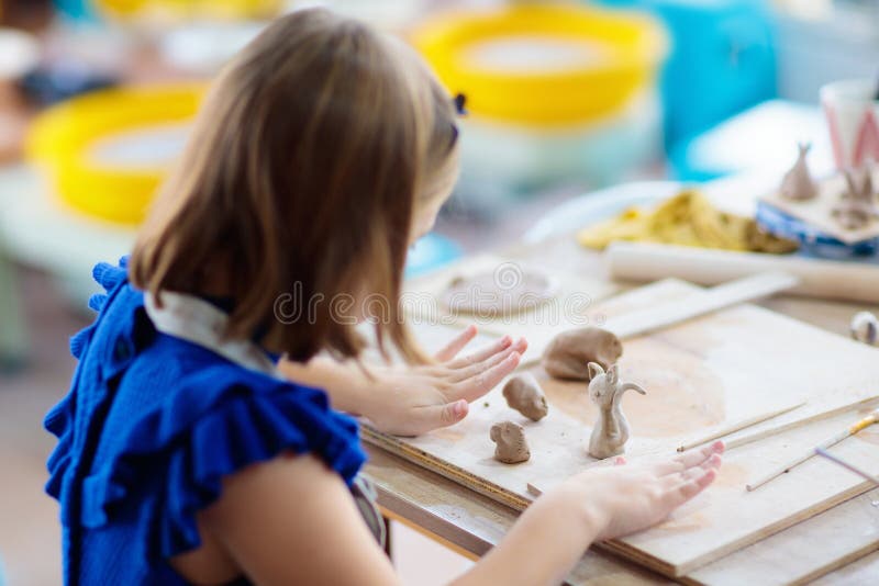 Child at pottery wheel. Kids arts and crafts class