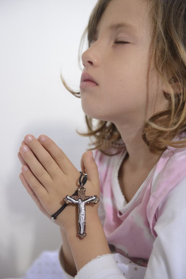 Little girl praying with cross. Little girl praying with cross