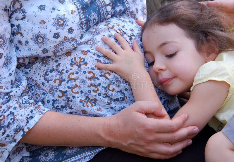 Una ragazza carina teneramente le coccole, la sua gravidanza le madri pancia, cercando di sentire i calci del bambino.