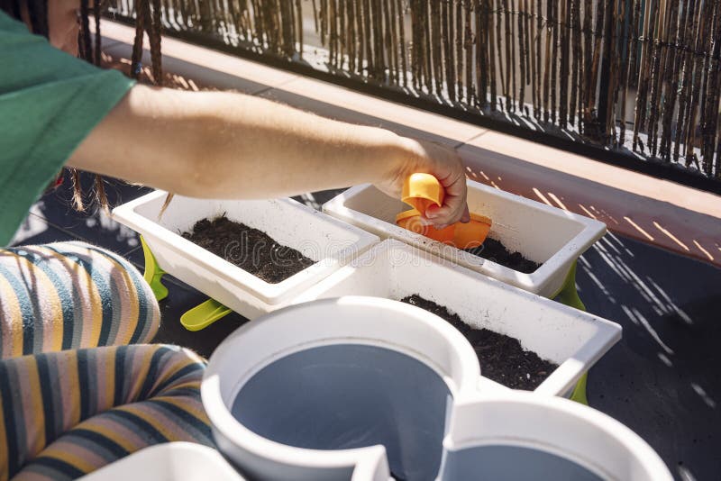 Child putting dirt in flower pots with a shovel stock photo Child putting dirt in flower pots with a shovel stock photo