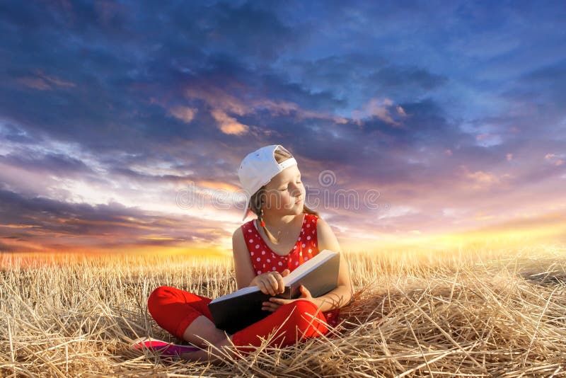 Child reading book or bible outdoors . Young Child`s Hands Praying on Holy Bible .