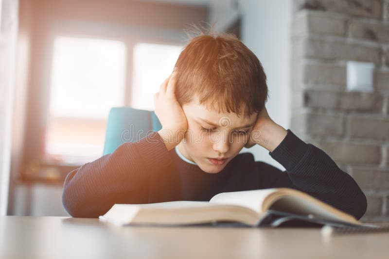 Child reading a book at the desk royalty free stock photography