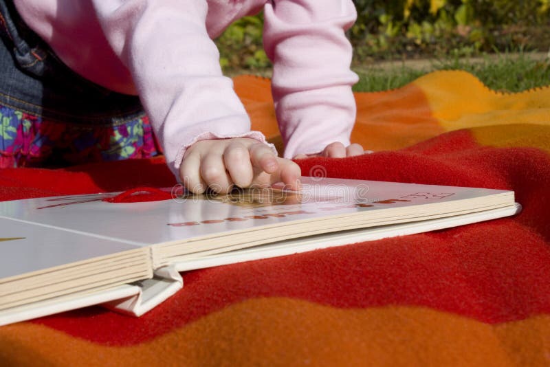 Child reading a book out in the garden