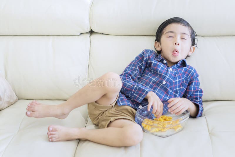 Child relaxing on the sofa with funny expression royalty free stock photography