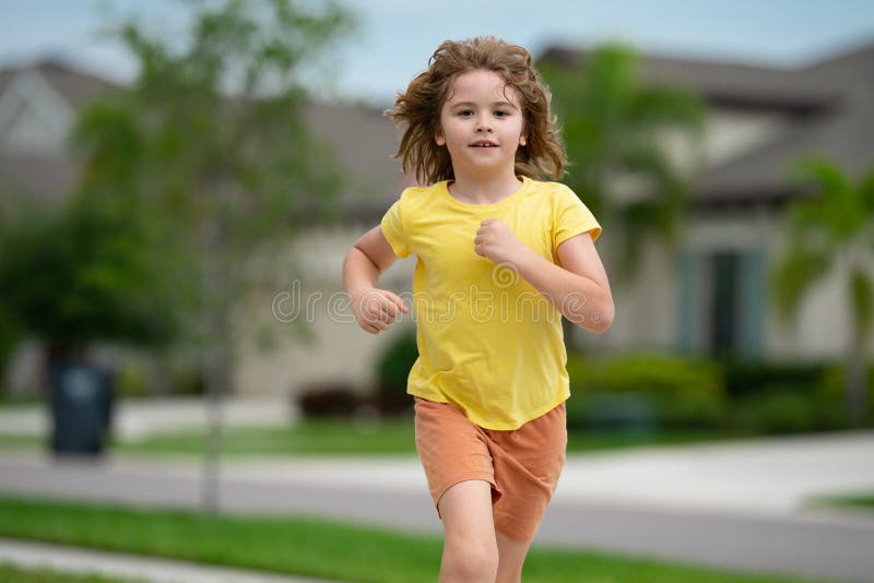 Child running in summer street. Kid enjoy run. Kid running on neighborhood. Kids run on city running road. Happy stock photography