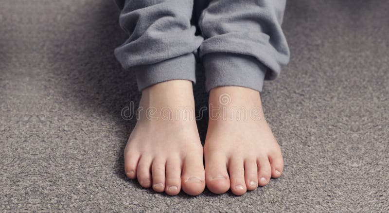 Child with bare feet in jeans. Lying on the bed. Foot barefoot Stock Photo