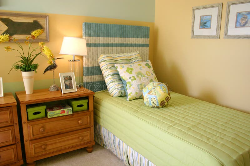 Child's Bedroom. Decorative child's bedroom with lime green and aqua bedspread, headboard and pillows, soft yellow walls and cherry chests Child's Bedroom. Decorative child's bedroom with lime green and aqua bedspread, headboard and pillows, soft yellow walls and cherry chests