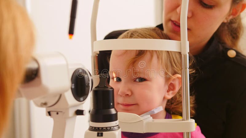 Child`s healthcare - ophthalmology - doctor checks eyesight at little girl