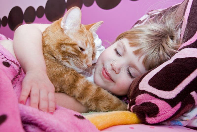little girl sleeping with cat in bed