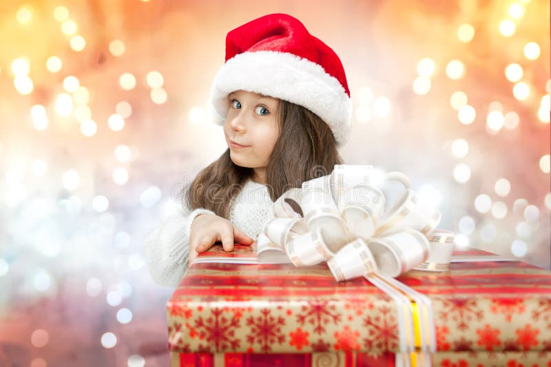 Child in Santa hat with gift box.