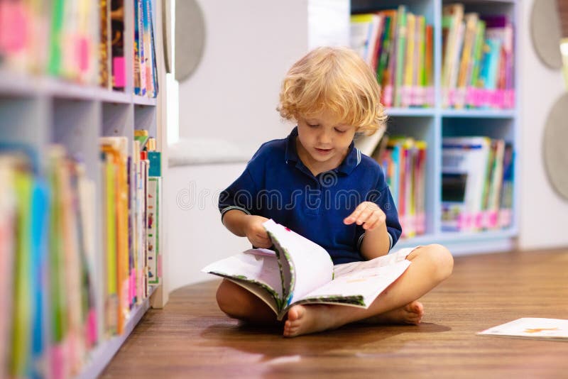 Child in school library. Kids reading books. Child in school library. Kids read books. Little boy reading and studying. Children at book store. Smart intelligent