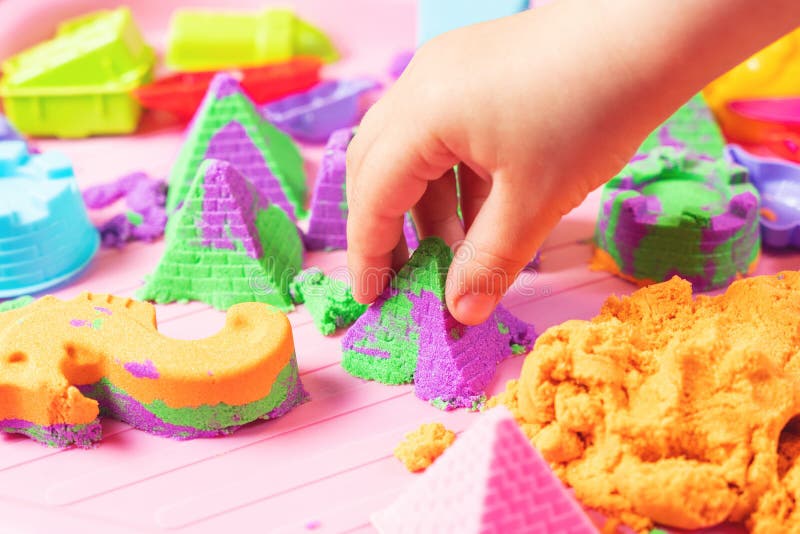 The Child Sculpts Figures from Multicolored Sand, Developing