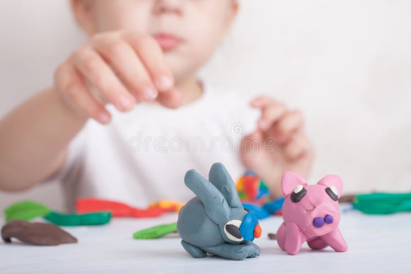 Child sculpts from plasticine pig and bunny stock image Child sculpts from plasticine pig and bunny stock image