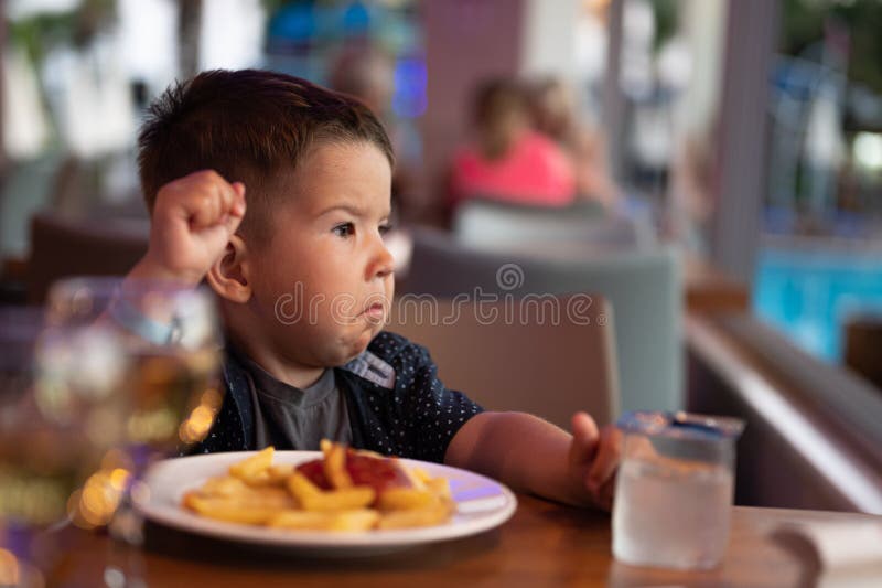 The Child is Sitting Alone in a Restaurant Stock Photo Image of
