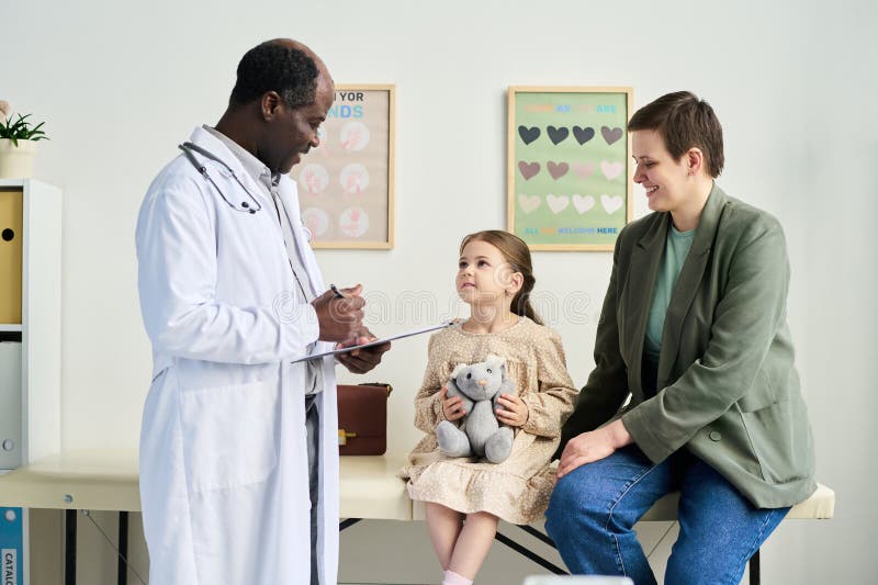 Doctor Examining Child with Parent in Pediatric Office royalty free stock images